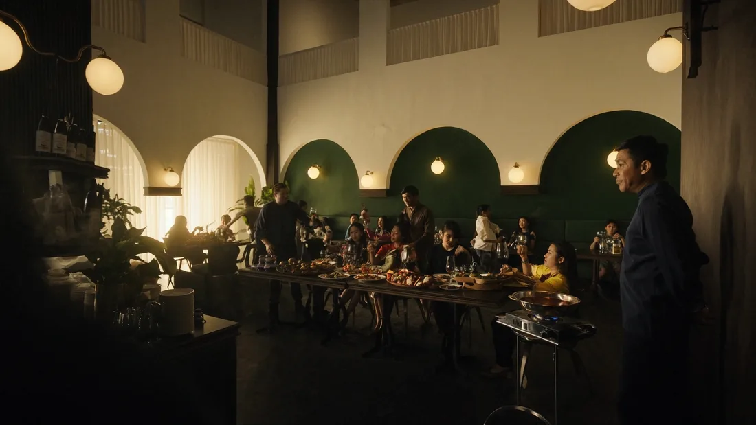 Concept restaurant scene with guests, team, and an operator together in the evening light.