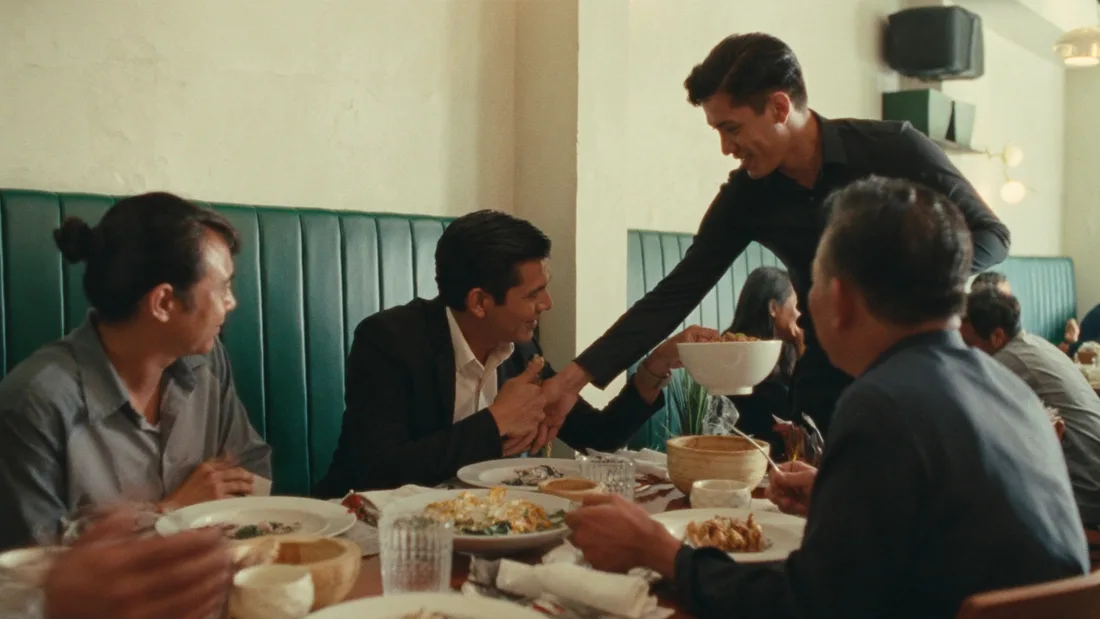 Concept scene of a server bringing a dish to guests sharing a meal.